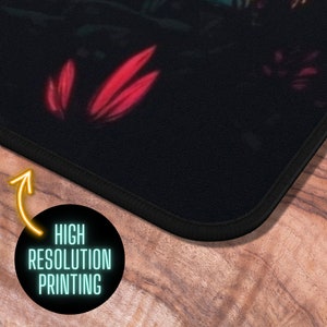 May include: A black mousepad with a colorful floral design. The mousepad has a stitched edge and the text "HIGH RESOLUTION PRINTING" is printed on the bottom edge.