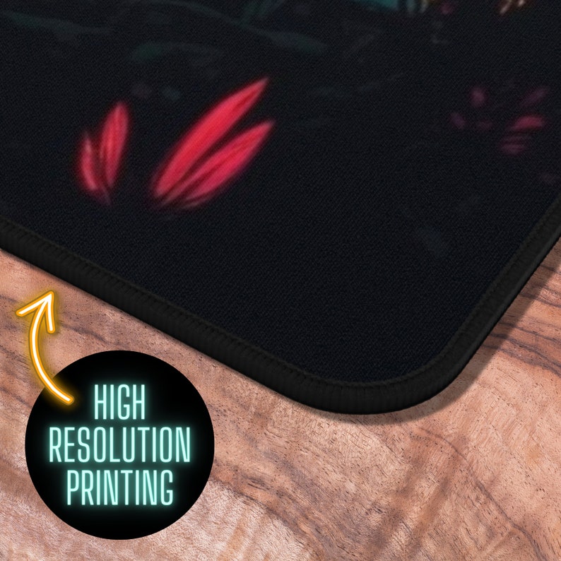 May include: A black mousepad with a colorful floral design. The mousepad has a stitched edge and the text "HIGH RESOLUTION PRINTING" is printed on the bottom edge.