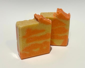 May include: Two bars of handmade soap with a swirl pattern of orange and yellow.
