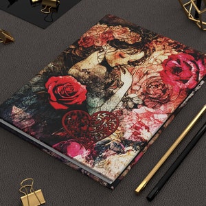 May include: A floral journal with a red heart and a woman's face on the cover. The background is a dark, textured design with red roses and other flowers.