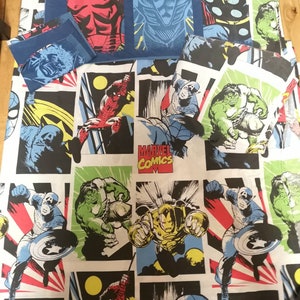May include: A white and black bedding set featuring a Marvel Comics theme. The bedding showcases various Marvel characters, including Iron Man, Spider-Man, Captain America, Hulk, and Thor. The bedding is made from a soft, comfortable fabric and is ideal for any Marvel enthusiast.