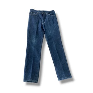 May include: Dark wash denim jeans. The jeans have a classic five-pocket design, a button and zipper closure, and a straight leg. The denim has a slightly faded appearance, giving them a vintage look. The jeans are a versatile wardrobe staple.