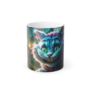 May include: A white ceramic mug with a colourful illustration of the Cheshire Cat. The cat has a wide grin, teal fur, and pink stripes. The background shows a forest scene with a lantern.