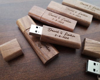Puede incluir: Memorias USB de madera grabadas con el texto "David & Laurie 2-4-2024". Las memorias son de color marrón claro y tienen una veta de madera natural.