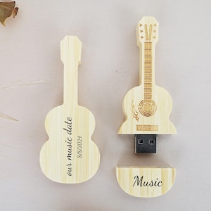 May include: Two wooden guitar-shaped USB flash drives. One drive has the text "our music date 8/18/2024" engraved on it. The other drive has the word "Music" engraved on it.