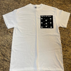 We’re all stars, glow in the dark Stars and lettering white T-shirt for adults