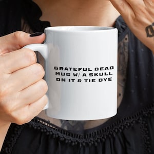 May include: White ceramic coffee mug with black text that reads "Grateful Dead Mug w/ a Skull on it & Tie Dye".