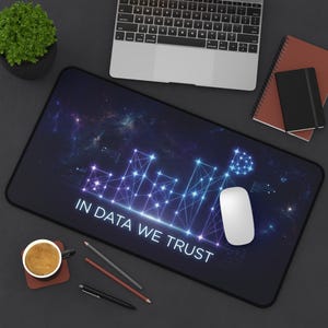 May include: A rectangular desk mat featuring a dark space-themed background with a glowing blue network of connected nodes and lines. The text IN DATA WE TRUST is printed in white capital letters across the bottom center of the mat.