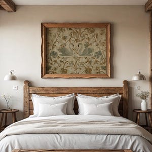 May include: A bedroom with a rustic wooden bed frame, white bedding, and a beige blanket. Above the bed is a framed artwork featuring two swans. Two small wooden side tables with lamps and a vase of flowers complete the room's decor.
