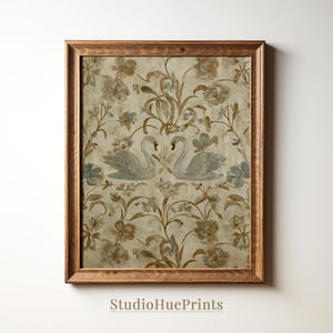 May include: A framed print featuring a vintage-style floral pattern with two swans. The artwork has a beige background with blue and brown floral accents. The frame is made of wood. The text "StudioHuePrints" is at the bottom.
