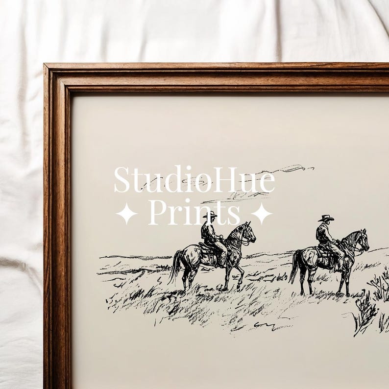 May include: A framed print featuring a black and white sketch of two riders on horseback traversing a grassy landscape. The print has the text "StudioHue Prints" in a decorative font.