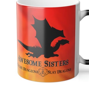May include: A white ceramic mug with a black handle. The mug has a red and orange ombre design with a black silhouette of a dragon. The text "Awesome Sisters Explore Dungeons & Slay Dragons" is printed on the mug.