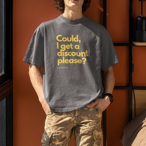 May include: A gray t-shirt with the text "Could, I get a discount please? I'm cheap" in yellow lettering.