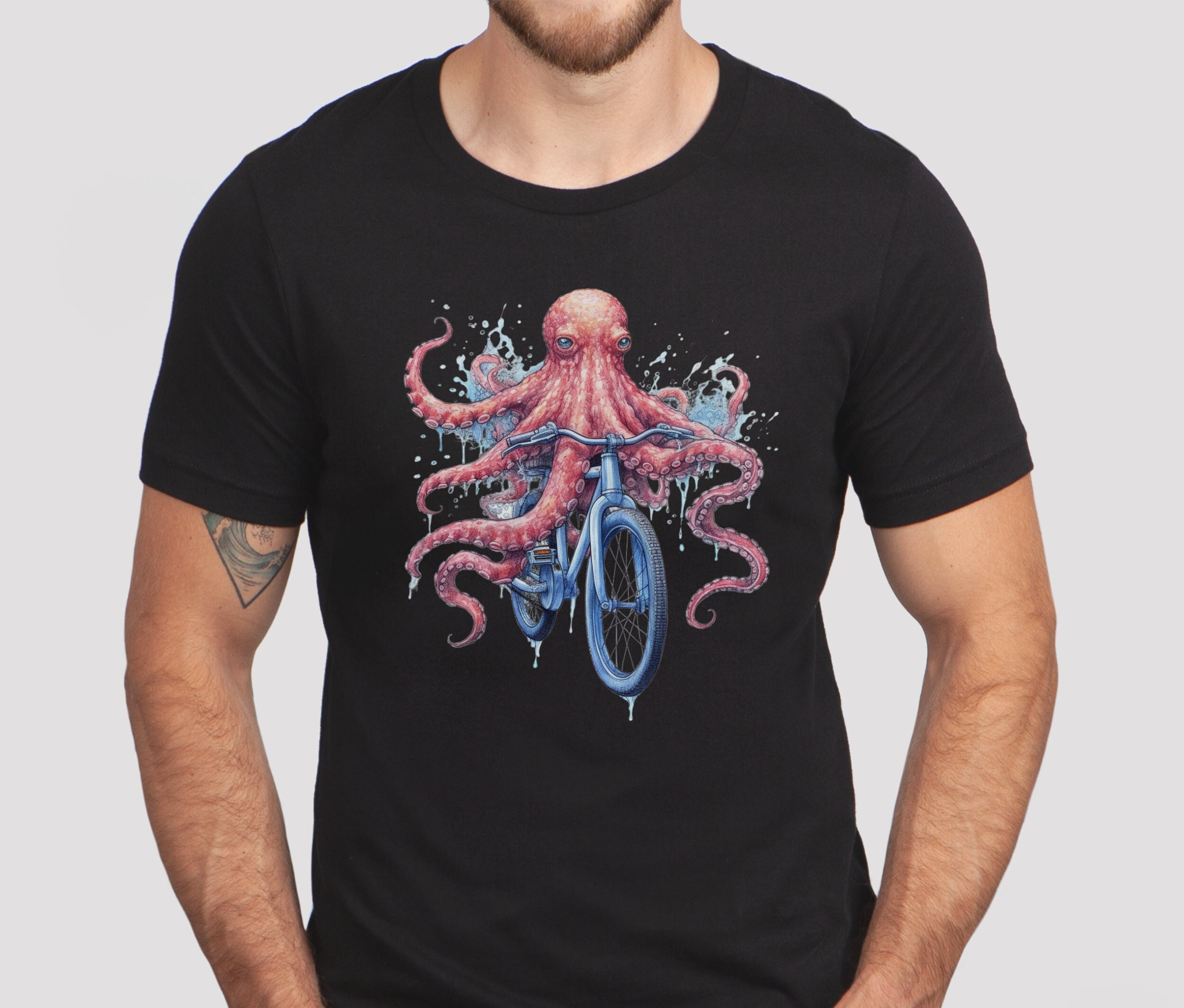 タコのユニセックス半袖Tシャツ、タコが自転車に乗っているシャツ