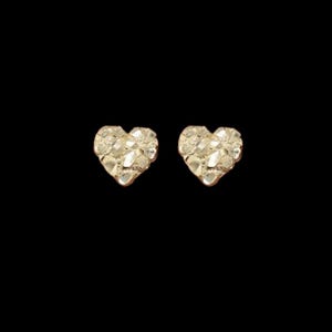 May include: A pair of gold heart-shaped earrings with a textured surface.