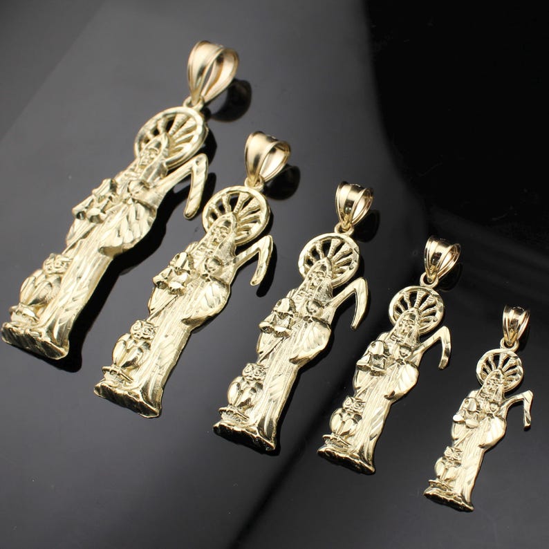 May include: Five gold-colored pendants featuring a religious figure with a halo and a curved staff. The pendants vary in size, with intricate details in the design. The background is a dark, reflective surface.