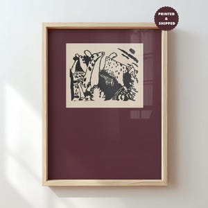 May include: A framed wall art print featuring a black and white abstract illustration with organic shapes and dotted textures on a cream background. The artwork is centered within a deep maroon mat inside a light-colored wooden frame. A circular badge in the top right corner contains the text PRINTED & SHIPPED.