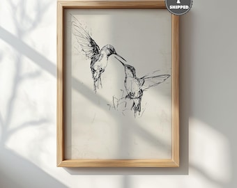 May include: A framed print featuring a black and white sketch of two hummingbirds. The birds are depicted in mid-flight, with their wings spread. The artwork has a vintage aesthetic, with the text "PRINTED & SHIPPED" in the upper right corner.