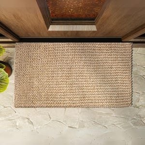 May include: A natural fiber doormat in a light brown color. The mat is made of woven strands and has a textured surface.