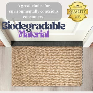 May include: A natural fiber doormat made from biodegradable material. The mat is beige and has a woven texture. The text "Biodegradable Material" is displayed above the mat. A premium quality seal is displayed in the top right corner.