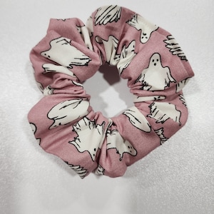 Op de afbeelding: Een roze scrunchie met een wit spookpatroon.