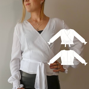 May include: White wrap blouse with long sleeves and a tie at the waist. The blouse has a ruffled detail at the cuffs. A line drawing of the blouse is shown in the background.