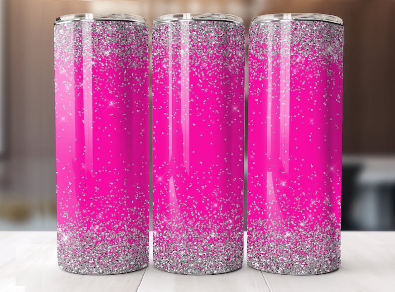 May include: Three stainless steel tumblers with a pink and silver glitter design. The tumblers are lined up in a row on a white surface.