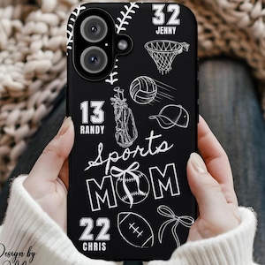 May include: Black phone case with white sports-themed illustrations, including a baseball, basketball hoop, volleyball, golf bag, and football. The text "Sports MOM" is prominently displayed, along with names and numbers. The case is held by a person.