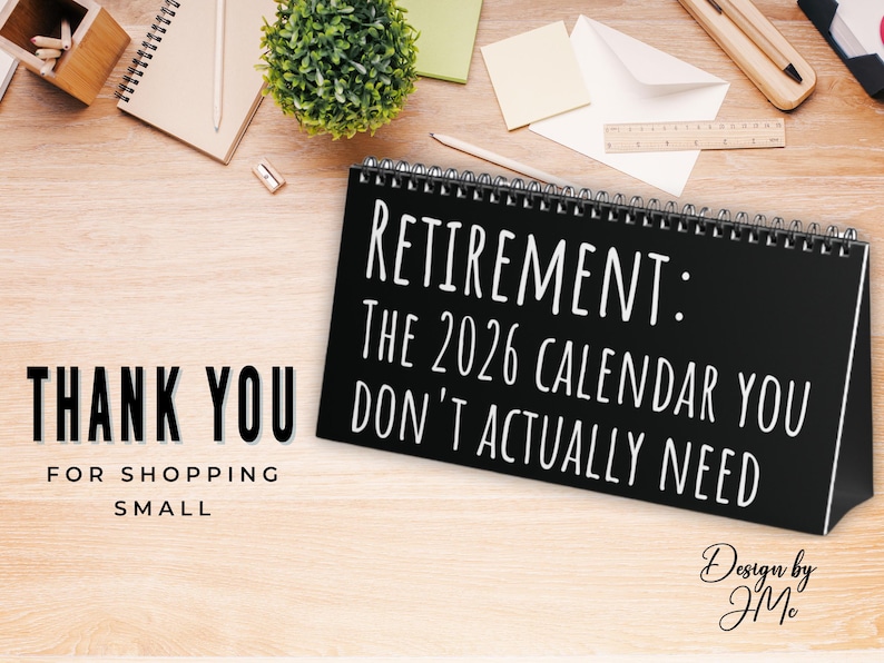 Puede incluir: Un calendario de escritorio negro con texto blanco que dice "RETIREMENT: THE 2026 CALENDAR YOU DON'T ACTUALLY NEED." Tambi&eacute;n son visibles las palabras "THANK YOU FOR SHOPPING SMALL". El calendario est&aacute; sobre una superficie de madera.