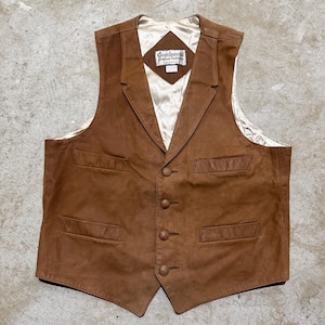 Pode incluir: Colete de couro castanho com gola entalhada, quatro botões e dois bolsos frontais. O colete tem forro de cetim e uma etiqueta que diz "Continental Leather Fashions."