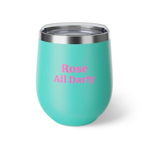 May include: A teal insulated wine tumbler with a silver rim. The tumbler has the words "Rose All Darty" printed in pink. The tumbler is designed to keep beverages cold for hours.