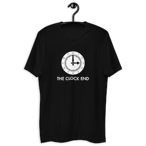 Op de afbeelding: Zwart T-shirt met een witte wijzerplaat en de tekst "THE CLOCK END" gedrukt op de voorkant.