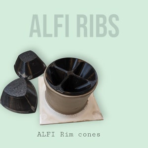 Op de afbeelding: Drie zwarte 3D-geprinte kegels, twee zijn klein en één is groter, staan op een witte keramische basis. De grotere kegel heeft een vierdelige binnenkant. De tekst "ALFI Rim cones" is onder de basis gedrukt.