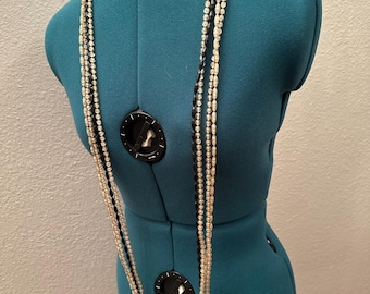 Lange, mehrsträngige Halskette, die schwarze Perlen mit klaren Faux-Perlen kombiniert.