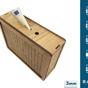 May include: A wooden money box with a slot for inserting bills. The box is made of light brown wood and has a grid pattern on the front. The box is 3 mm thick.