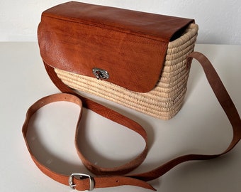 Handgeweven tas van stro en riet met een schouderband van echt Marokkaans leer, in boho-stijl.