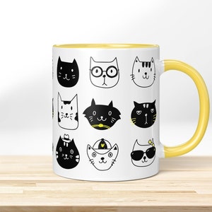 Può includere: Tazza in ceramica bianca con interno e manico gialli, decorata con un motivo ripetuto di volti di gatti stravaganti in bianco e nero. I volti dei gatti hanno varie espressioni e accessori, come occhiali e cappelli.