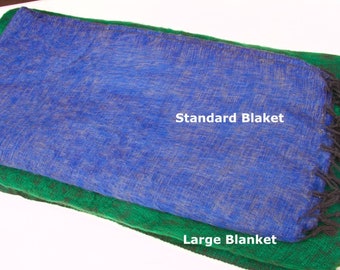Pode incluir: Duas mantas tecidas, uma azul e outra verde, com franjas pretas. A manta azul é etiquetada como "Standard Blanket" e a manta verde como "Large Blanket".