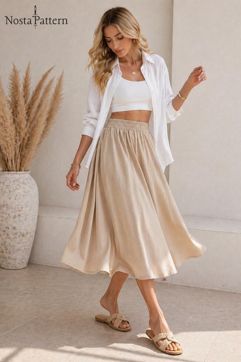May include: A woman wearing a white crop top, a white button-down shirt, and a beige midi skirt. The skirt has an elastic waistband. The woman is also wearing sandals. The image has the text "Nosta Pattern" in the top left corner.