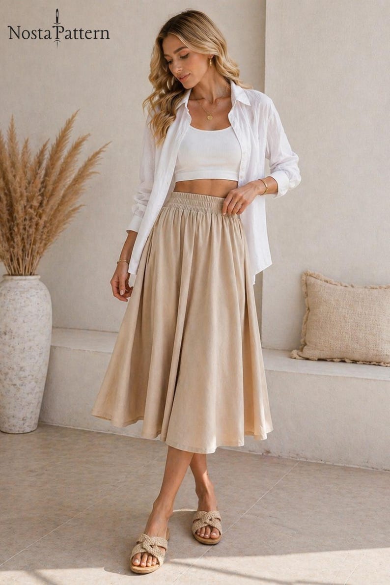 May include: A woman wearing a white crop top, white button-down shirt, and a beige midi skirt. The skirt has an elastic waistband. The image also shows a pair of woven sandals. The text "Nosta Pattern" is in the top left corner.