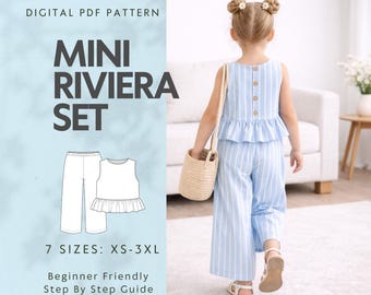 May include: A digital PDF pattern for a Mini Riviera Set, including a top and pants, with sizes XS-3XL. The image shows a young child wearing a blue and white striped outfit, with a matching top and wide-leg pants. The outfit has a ruffled hem and wooden buttons.