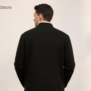 May include: A black coat with a mandarin collar and long sleeves. The person is viewed from the back, with the white collar of a shirt visible. The brand name "Nosta Pattern" is in the upper left corner.