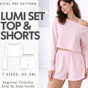 Op de afbeelding: Een lichtroze Lumi-set, bestaande uit een top en shorts, wordt getoond. De top heeft lange mouwen en een off-the-shoulder ontwerp. De shorts hebben een geschulpte zoom. De tekst bevat "LUMI SET TOP & SHORTS" en "7 SIZES: XS-3XL".