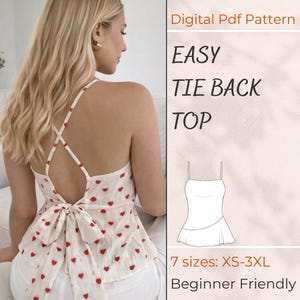Puede incluir: Una blusa con lazo en la espalda de color crema con un estampado de corazones rojos. La blusa tiene un diseño de espalda cruzada y un lazo en la cintura. La imagen también incluye el texto "EASY TIE BACK TOP" y "Beginner Friendly".