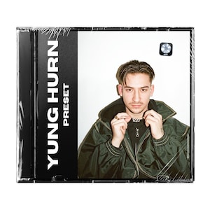 Könnte beinhalten: Ein CD-Gehäuse mit schwarzem Hintergrund und weißem Text, der "YUNG HURN PRESET" lautet. Die Vorderseite des Gehäuses zeigt ein Foto einer Person, die eine grüne Jacke und ein schwarzes Hemd trägt. Die Person blickt in die Kamera und hat einen ernsten Gesichtsausdruck.