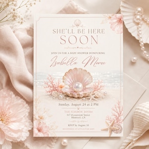 May include: A baby shower invitation with a seashell and pearl design. The invitation features the text "She'll Be Here Soon" and details for a baby shower honoring Isabella Moore, including the date, time, and location.