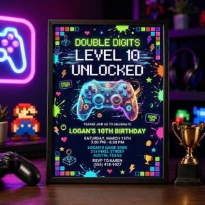 May include: A framed invitation for Logan's 10th birthday, featuring a neon-style controller graphic. The text reads "Double Digits, Level 10 Unlocked," with event details including date, time, and location in Austin, Texas.