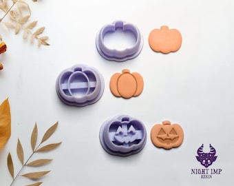 Puede incluir: Tres cortadores de galletas de calabaza de plástico morado y tres formas de calabaza naranja. Las formas de calabaza tienen una cara tallada en un lado y una forma de calabaza simple en el otro.