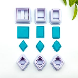 Könnte beinhalten: Satz mit neun Ausstechern aus Kunststoff in verschiedenen Formen, darunter Quadrate, Diamanten und ein Kleeblatt. Die Ausstecher sind lila und weiß und werden auf einer weißen Oberfläche gezeigt.