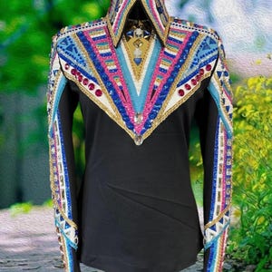 May include: Black long-sleeved shirt with a decorative collar and shoulder design. The collar and shoulders feature a vibrant pattern of blue, pink, white, and gold embellishments, including rhinestones. The sleeves also have decorative patterns.